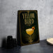 A framed poster with the title "Yellow Bird" on a black background, featuring an illustration of a cocktail glass with a lemon slice.