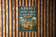 A vintage metal sign for the Abbaye de Saint-Savin in Gartempe, France, featuring an illustration of a church with a tower.