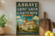 A vintage-style sign for the Abbaye de Saint-Savin in Gartempe, France, featuring an illustration of a church with a bell tower.