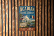 A vintage-style metal sign for the Acadian Cultural Landscape in Louisiana, featuring a church, a river, and a boat.