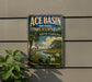 A vintage-style sign for the Ace Basin National Estuarine Research Reserve in South Carolina, featuring a seagull and a tropical landscape.