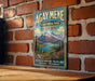 A vintage-style sign for Agay Mene Territorial Park in Yukon, featuring a scenic mountain landscape with a lake and pine trees.