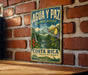 A vintage-style sign for the Agua y Paz Biosphere Reserve in Costa Rica, featuring a colorful illustration of a toucan and lush tropical foliage.