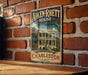 A vintage-style metal sign for the Aiken-Rhetts House in Charleston, South Carolina, featuring an illustration of the historic building.
