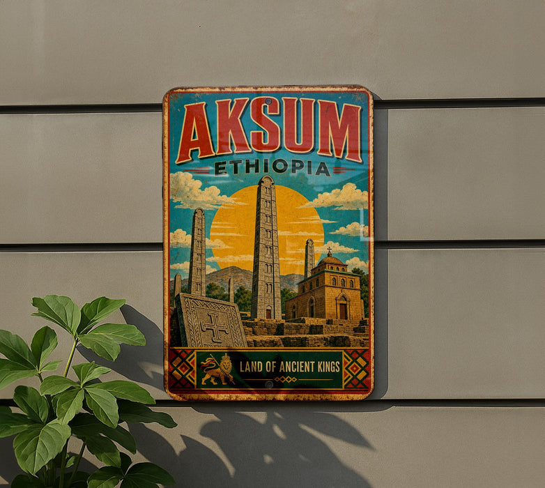 A vintage-style metal sign with the text "AKSUM Ethiopia" and an illustration of the ancient city of Akosma, featuring tall obelisks and other landmarks.
