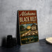 A vintage-style metal sign for Alabama's Black Belt National Heritage Area, featuring a rural landscape with a cotton plantation and a house.