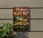 A vintage-style sign for Alabama's Black Belt National Heritage Area, featuring a farm scene with cotton fields and a cotton mill.