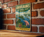 a vintage-style metal sign for the Amazon Rainforest National Park in Brazil, with a large illustration of a pink dolphin swimming in the water.