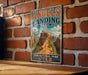 A vintage-style metal sign for the Angels Landing Trail in Zion National Park, Utah, featuring a mountain landscape with a winding trail.