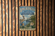 A vintage metal sign for the Apalachicola National Estuarine Research Reserve in Florida, featuring a bird and a shell, is displayed on a wooden wall.