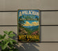 A vintage metal sign for the Appalachian Forest National Heritage Area in West Virginia, featuring a scenic mountain landscape with pine trees and pink flowers.