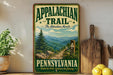 A vintage-style sign for the Appalachian Trail in Pennsylvania, featuring a scenic mountain landscape with a pine tree and a trail marker.