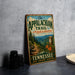 A vintage-style metal sign for "The Appalachian Trail" in Tennessee, featuring a scenic mountain landscape and trail.