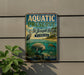 A vintage-style metal sign for Aquatic Preserve at St. Joseph Bay, Florida, featuring an illustration of a manatee and a bird in a tropical setting.