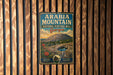 A vintage metal sign for the Arabia Mountain National Heritage Area in Georgia, featuring a mountain landscape with a waterfall and flowers.