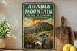 A vintage-style sign for the Arabia Mountain National Heritage Area in Georgia, featuring a scenic image of a rocky mountain landscape with cacti and a blue pool.