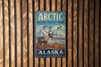 A vintage-style sign for the Arctic National Wildlife Refuge in Alaska, featuring an illustration of a reindeer and mountains in the background.