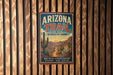 A vintage metal sign for the Arizona Trail, featuring a desert landscape with a cactus and mountains in the background.