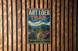 A vintage-style metal sign for the Art Loeb Trail in North Carolina, featuring a scenic mountain landscape with a winding trail and colorful wildflowers.