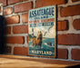 A vintage metal sign for Assateague Island National Seashore, Maryland, featuring a horse, lighthouse, and seagulls in the ocean.