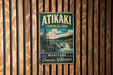 A vintage metal sign for Atikaki Provincial Park in Manitoba, Canada, featuring a scenic landscape with a waterfall and pine trees.