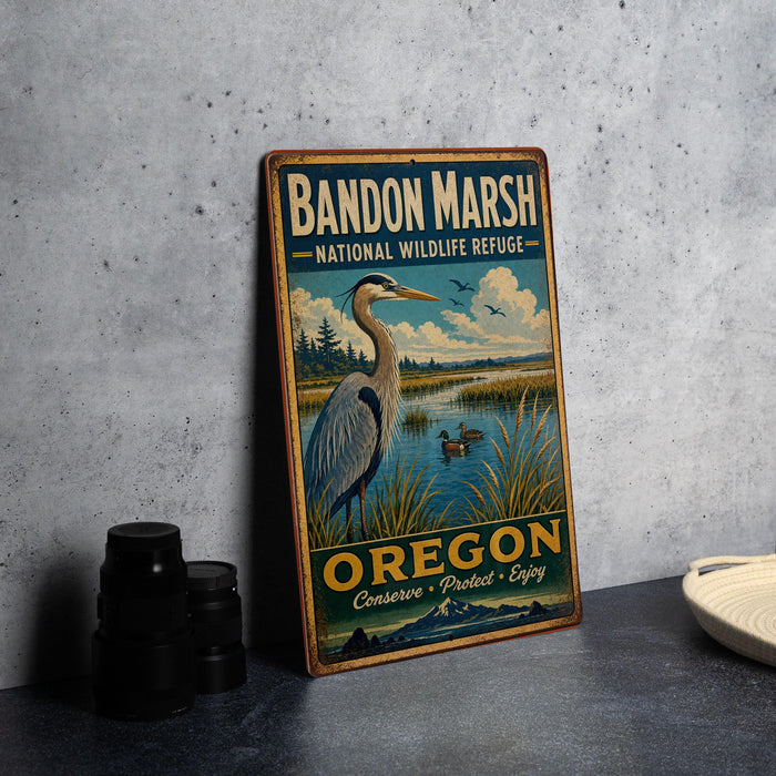 A vintage metal sign for Bandon Marsh National Wildlife Refuge in Oregon, featuring a large heron and a scenic landscape.