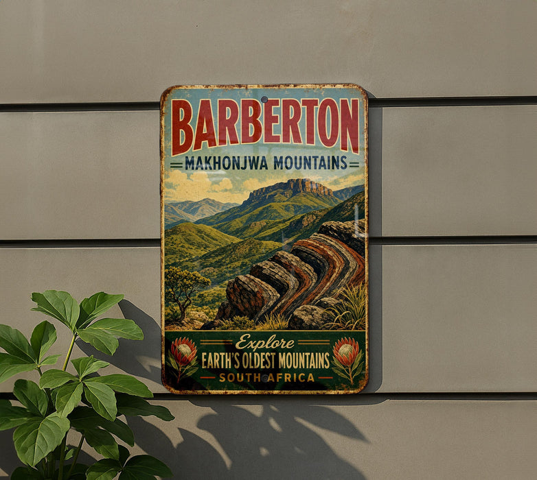 A vintage metal sign advertising the Barbarton Makhonjwa Mountains, featuring a scenic mountain landscape with a mountain peak and a river.