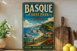 A vintage-style poster of Basque Coast Park in Spain, featuring a scenic coastal landscape with cliffs, a beach, and a small village.