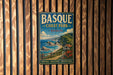 A vintage-style metal sign for Basque Coast Park, Spain, featuring a scenic coastal landscape with cliffs, a lighthouse, and a small village.