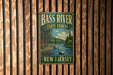 A vintage metal sign for Bass River State Forest in New Jersey, featuring a scenic illustration of a river surrounded by trees and mountains.