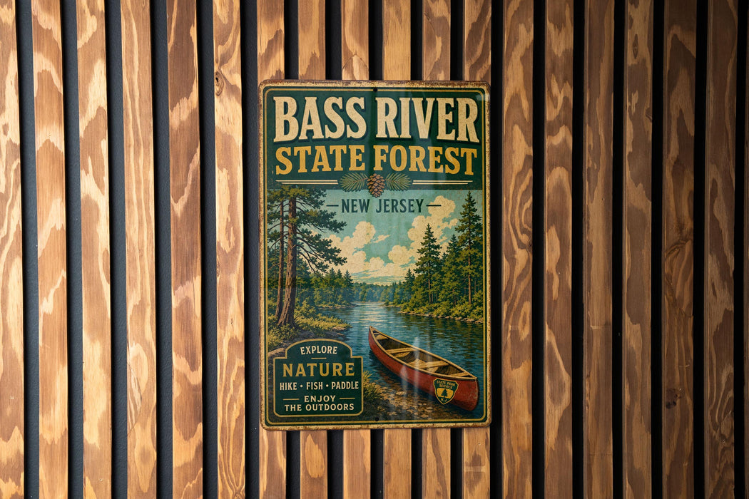 A vintage metal sign for the Bass River State Forest in New Jersey, featuring a canoe and a scenic landscape.