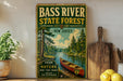 A vintage-style metal sign for Bass River State Forest in New Jersey, featuring a canoe on a river surrounded by pine trees.