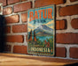 A vintage-style metal sign displaying the name "Batur Park" and the word "Indonesia" is hanging on a brick wall.