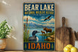 A vintage-style metal sign for Bear Lake National Wildlife Refuge in Idaho, featuring an illustration of various wildlife, including a moose, a loon, and a duck, set against a scenic landscape with mountains and a lake.