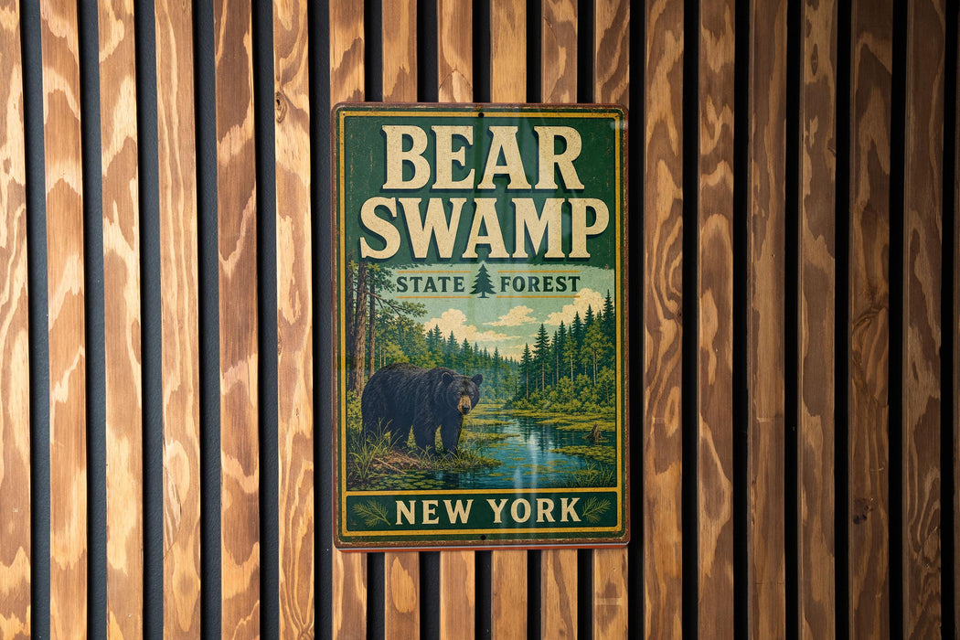 A metal sign with the text "BEAR SWAMP STATE FOREST NEW YORK" and an illustration of a bear in a forest setting.