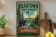 A vintage metal sign for the Beartown State Forest in Massachusetts, featuring a bear in a forest setting.