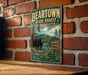 A vintage-style metal sign for the Beartown State Forest in Massachusetts, featuring a black bear in a forest setting.