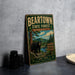 A vintage-style metal sign for the Beartown State Forest in Massachusetts, featuring a bear and a scenic landscape.