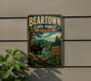 A vintage-style metal sign for the Beartown State Forest in Massachusetts, featuring a black bear in a forest setting.