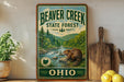 A vintage-style sign for Beaver Creek State Forest in Ohio, featuring a beaver in a natural setting with a river and trees.
