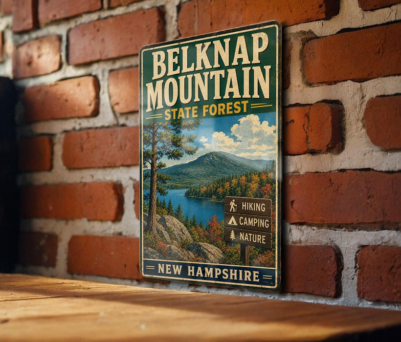 A vintage metal sign for Belknap Mountain State Forest in New Hampshire, featuring a scenic mountain landscape with a lake and hiking trails.