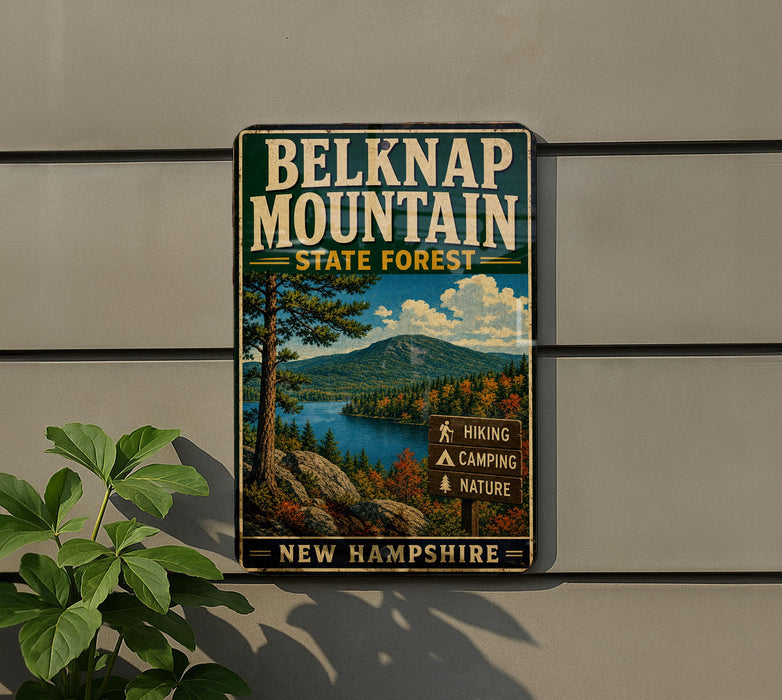 A vintage metal sign for Belknap Mountain State Forest in New Hampshire, featuring a scenic landscape with a mountain, lake, and forest.