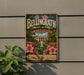 A vintage-style metal sign for Bellinggrath Gardens and Home in Alabama, featuring a garden scene with a fountain and pink flowers.