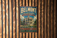 A vintage metal sign for Belmont mansion in Nashville, Tennessee, featuring a large illustration of the mansion and the text "Belmont mansion Nashville's Grand Dame" against a wooden background.