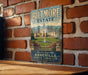 A vintage-style metal sign with the text "Biltmore Estate" and "Asheville, North Carolina" is displayed on a brick wall.