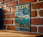 A vintage-style metal sign for Biscayne National Park, Florida, featuring a turtle, fish, and coral, mounted on a brick wall.