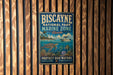 A vintage-style metal sign for Biscayne National Park's Marine Zone, featuring an illustration of a turtle, fish, and coral reef, along with the text "PROTECT OUR WATERS EXPLORE PRESERVE".