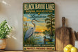 A vintage-style metal sign for Black Bayou Lake, Louisiana, featuring an illustration of a heron and a duck in a natural setting.