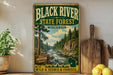 A vintage-style sign for the Black River State Forest in Wisconsin, featuring a scenic illustration of a river surrounded by pine trees and mountains.