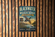A vintage metal sign for the Blackwater National Wildlife Refuge in Maryland, featuring a duck flying over a lake and a bird perched on a tree branch.